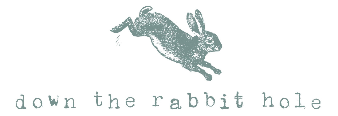 A vintage engraving style illustration of a dusty green rabbit jumping over typewriter text that reads, down the rabbit hole