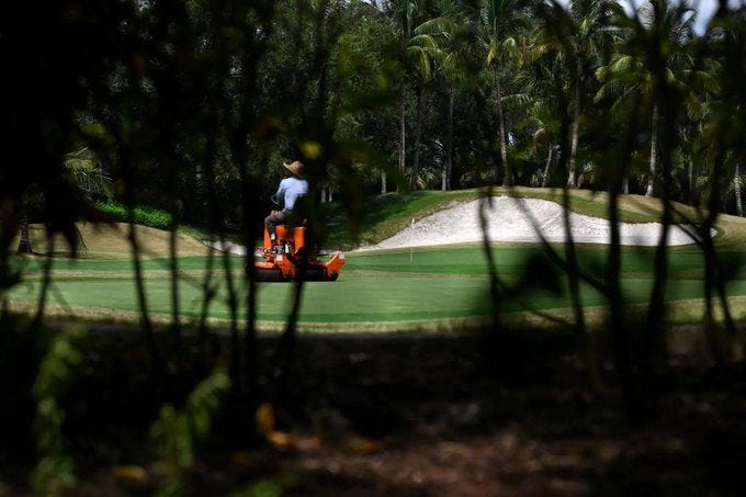 May be an image of 1 person, golfing, golf cart and golf course