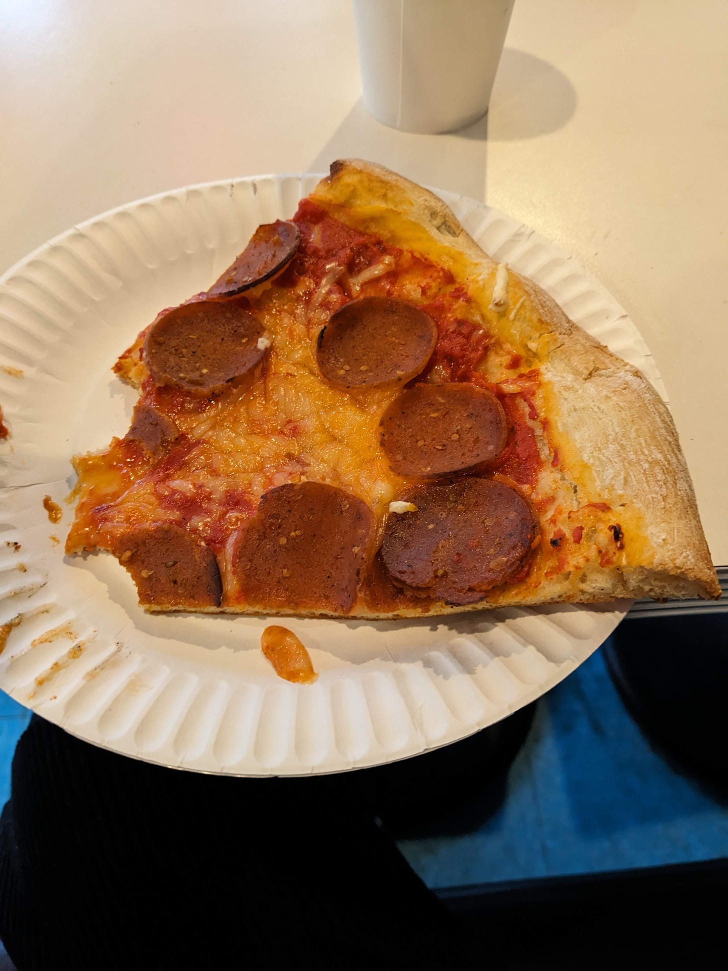a few bites out of a vegan pepperoni slice of pizza
