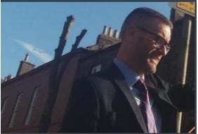 A person in a suit and tie

Description automatically generated