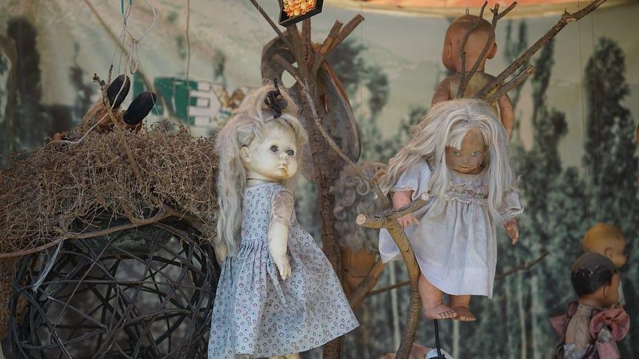 Two haggard dolls with dresses.
