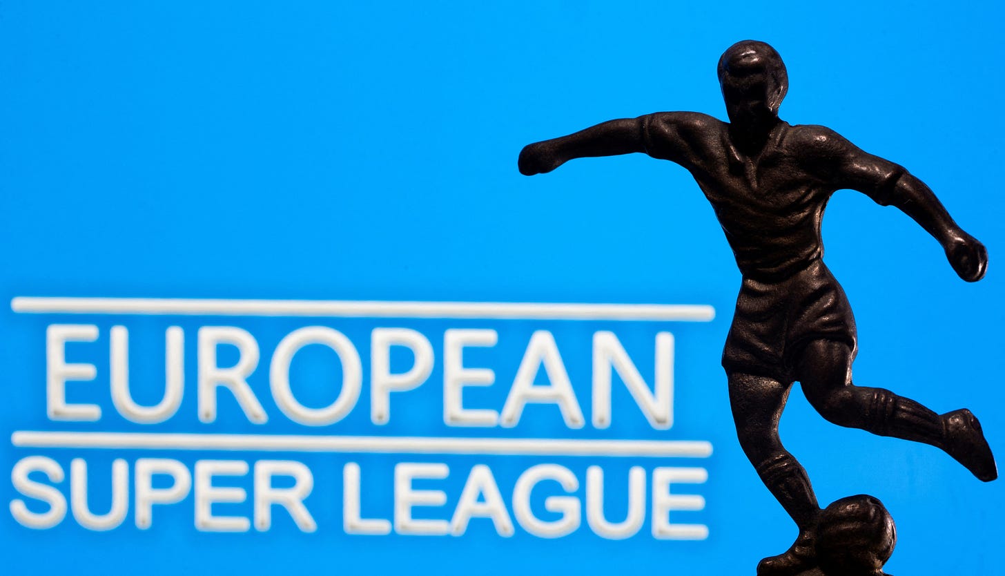 A metal figure of a football player with a ball is seen in front of the words "European Super League" in this illustration