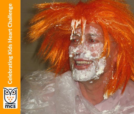 mr bagnato with pie on his face while wearing an orange wig