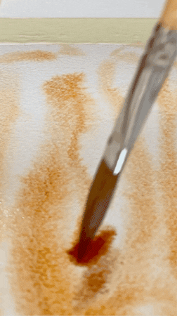 GIF close up of abstract watercolour painting process, with en earthy brown watercolour flowing and spreading as it interact with the wet paper