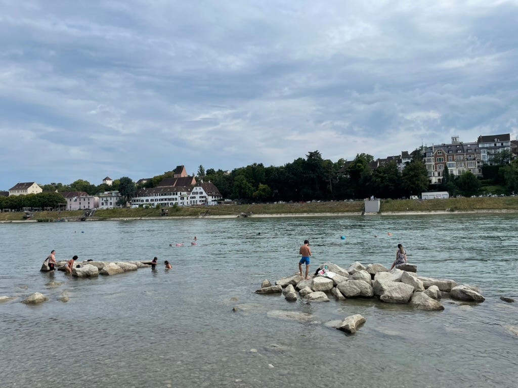 People relax on boulders in the Rhine in Basel.