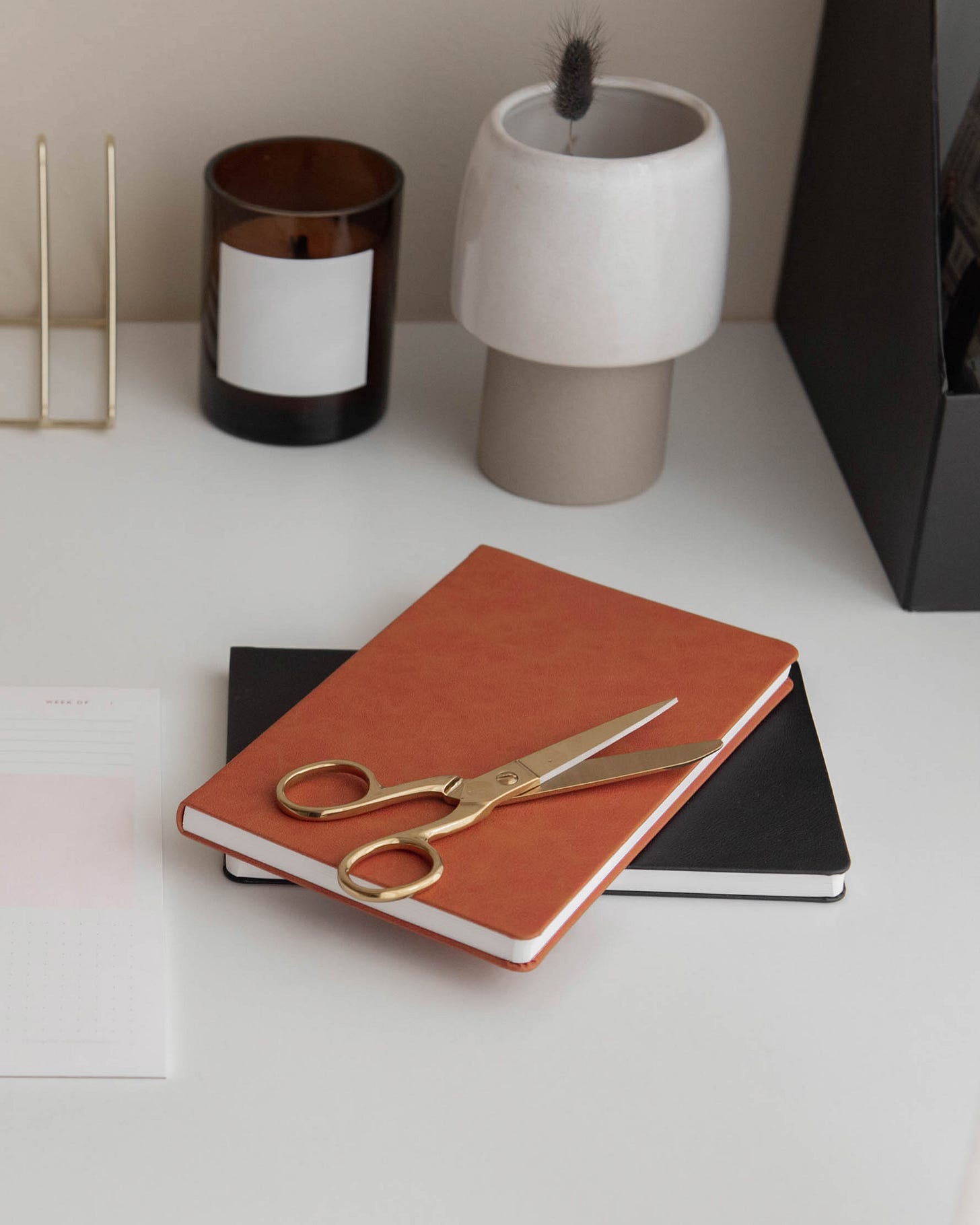 orange notebook on a table with a candle