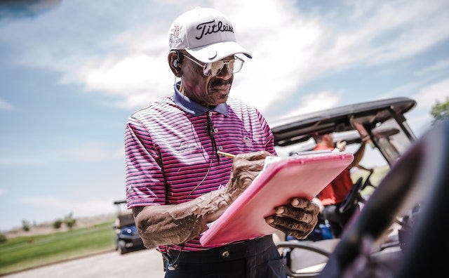 A campaign volunteer checking his voter’s list at a Golf Course campaign event. 
