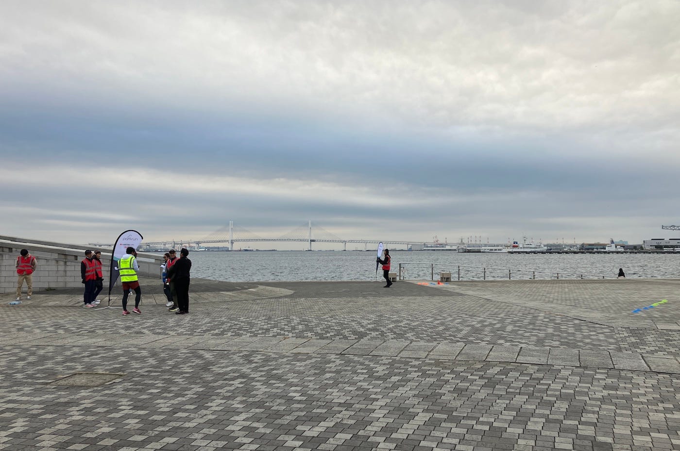 Large area of concrete in the park, with parkrun flags and cones to mark the finish