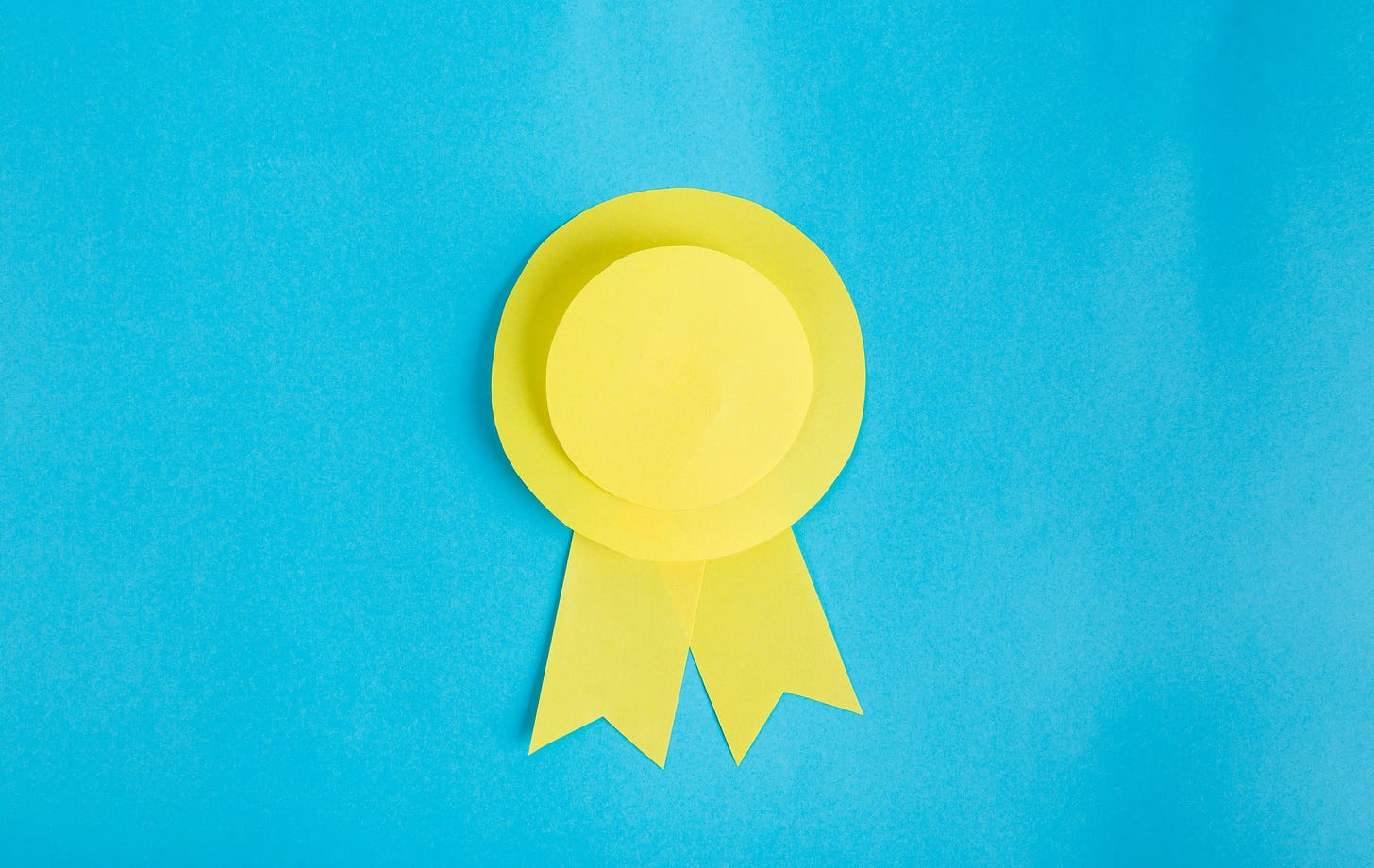 Yellow paper award ribbon on blue background