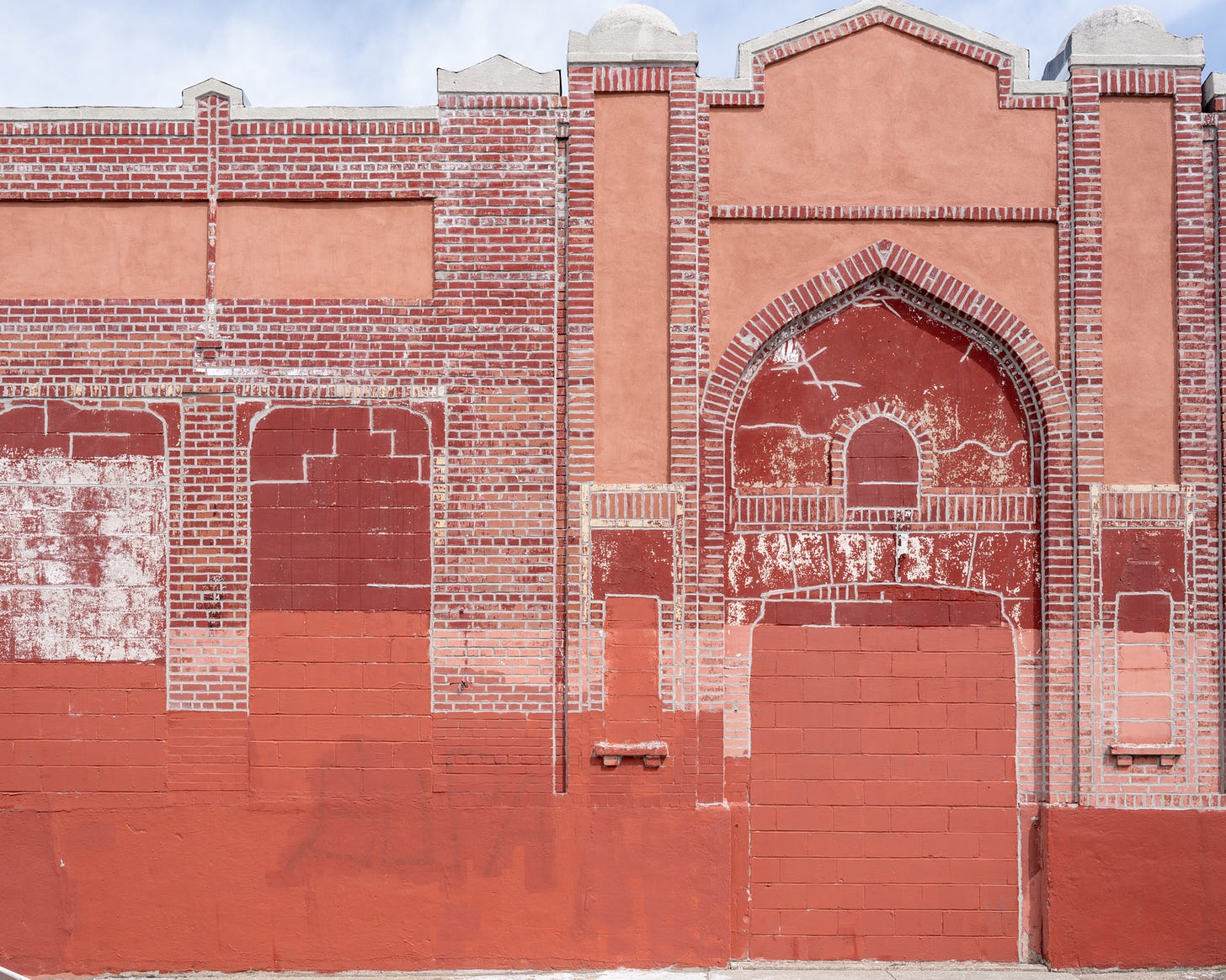 Red painted, moorish looking wall with bricks