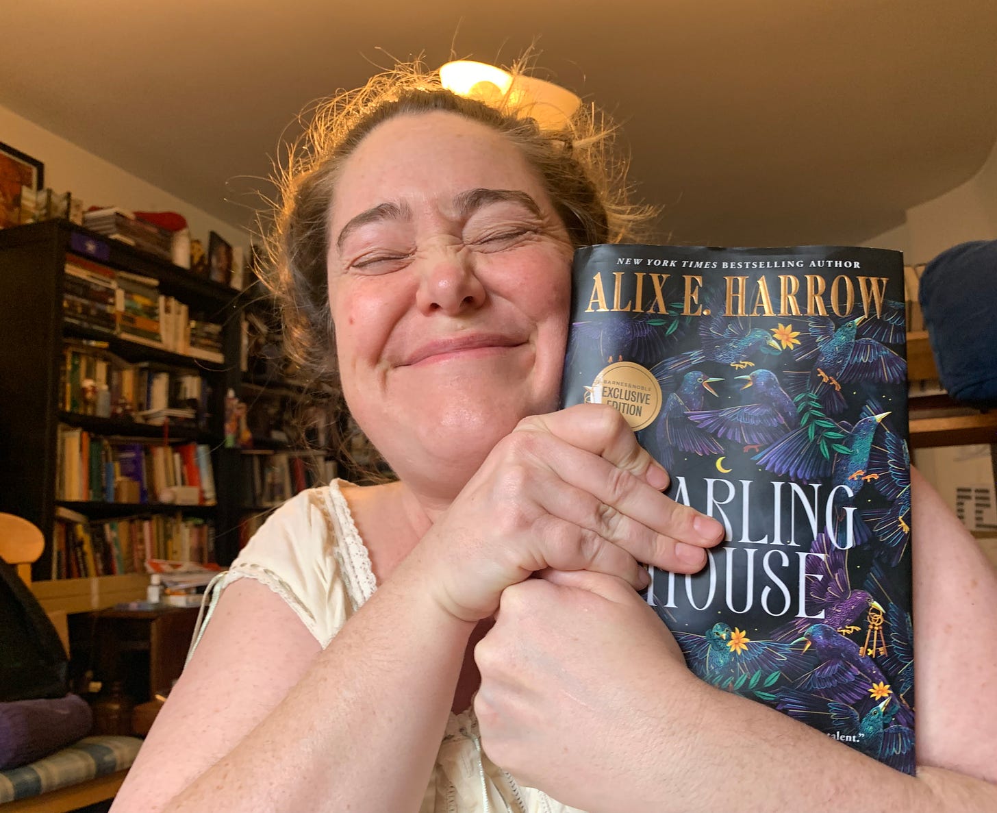 image of the writer, hugging the book "Starling House," looking blissful