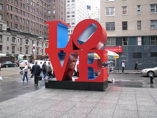 It’s a statue with the letters L-O-V-E in Didone type stacked on toppa one another, with the “O” bein’ kinda tilted.