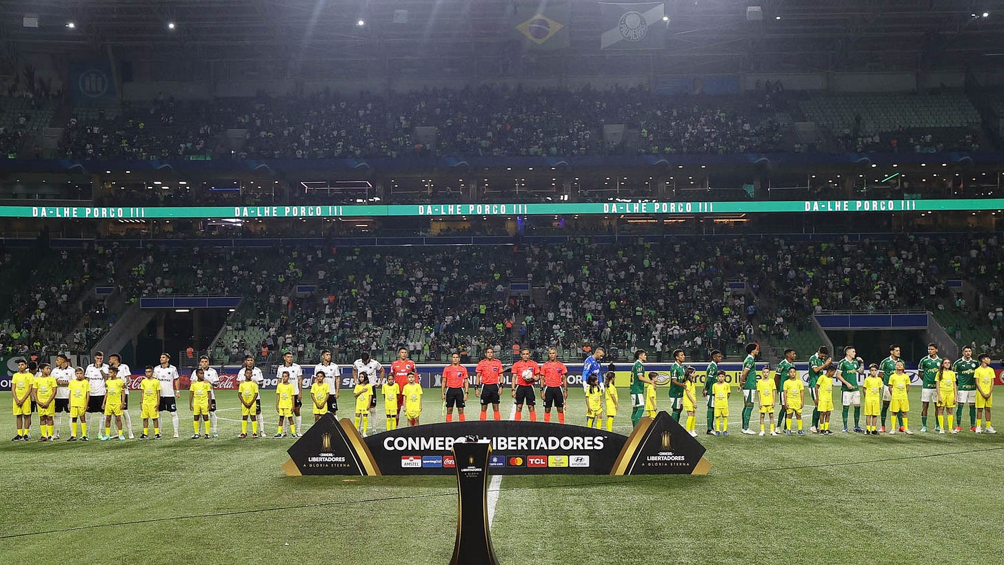 Jogadores de Palmeiras e Liverpool (URU) durante a execução do hino nacional. Ao fundo, é possível ver as arquibancadas do setor Central Leste do Allianz Parque com vários espaços vazios.