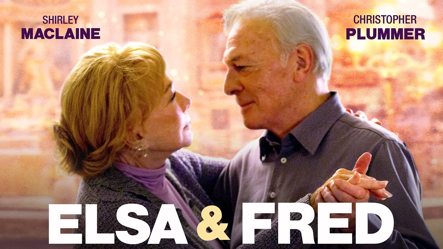 A movie poster of the 2014 film Elsa & Fred. It has been cropped to a horizontal format so only the head & shoulders are visible of the main two characters, a man and a woman embrace in a waltz pose hand in hand. The actor names, Shirley Maclaine and Christopher Plummer are in block capital purple font in the top right and left corners.