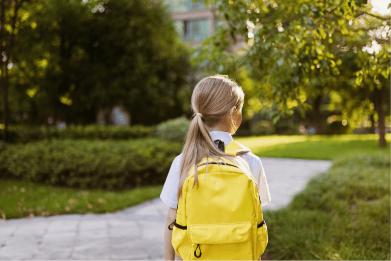Back to school little girl with yellow backpack