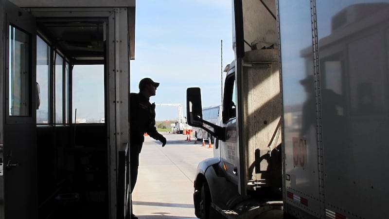 FILE - Border Patrol agent Eric Mendoza speaks to the driver of a tractor-trailer passing...