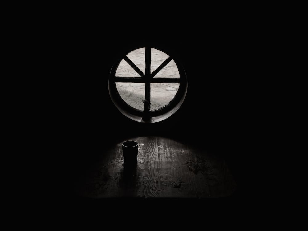 Free Grayscale Photography of Cup Beside Closed Window in Empty Room Stock Photo