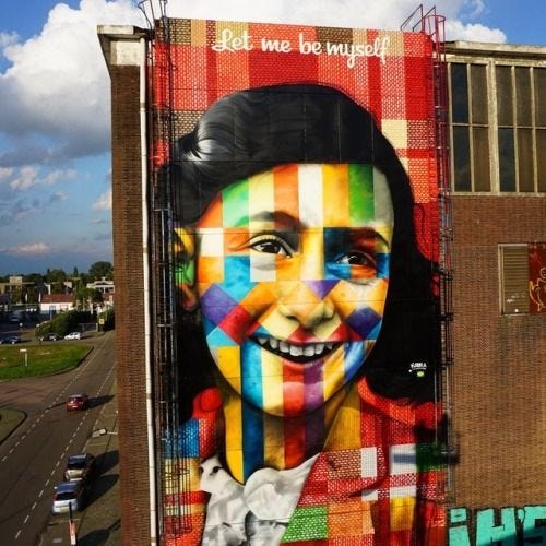 This may contain: a large mural on the side of a building with a woman's face painted on it
