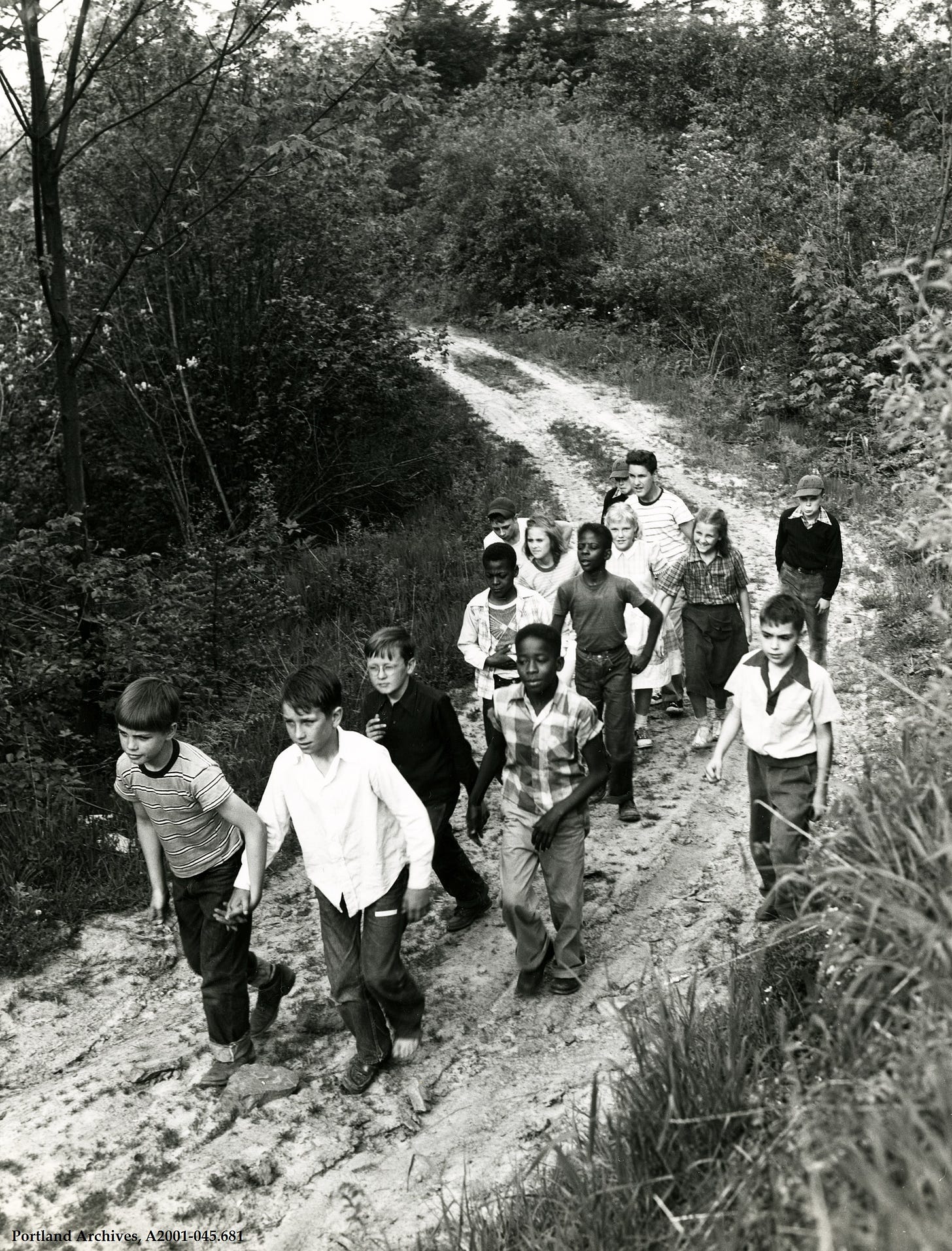 Black and white photo of kids walking in a forest