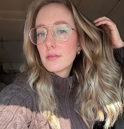selfie of kara mcgrath wearing glasses and a brown sweater