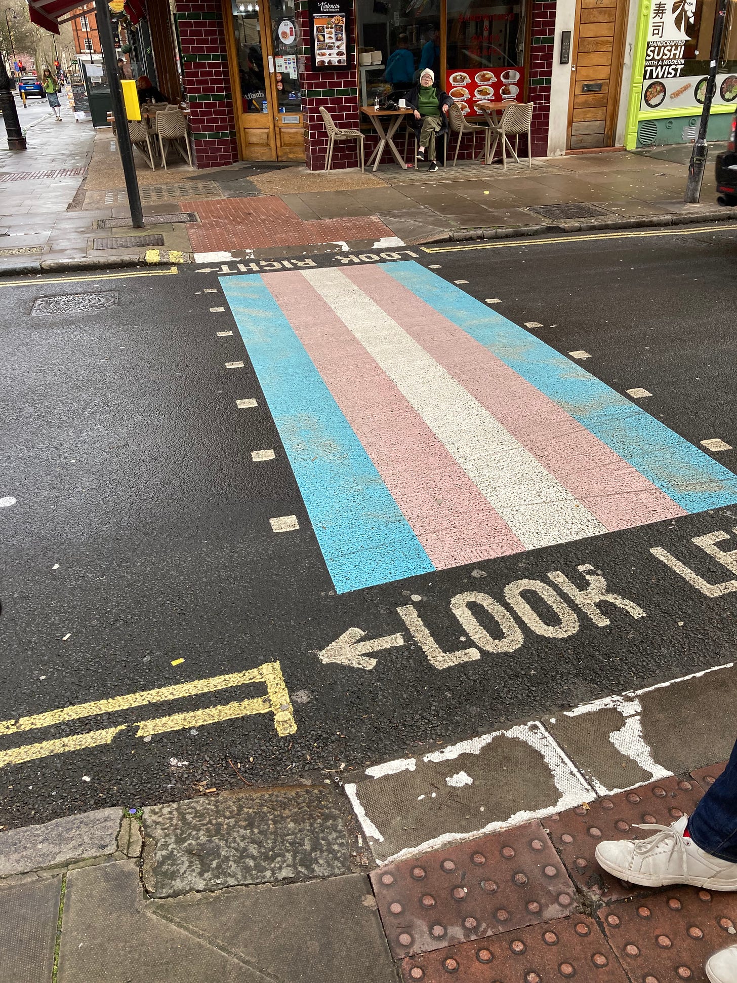 Photograph of a road crossing, which has been painted as a transgender flag.