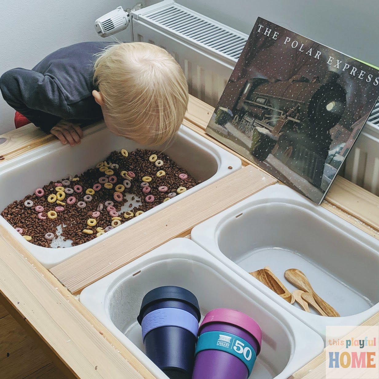 A blonde toddler peers into a Polar Express themed hot chocolate sensory bin 