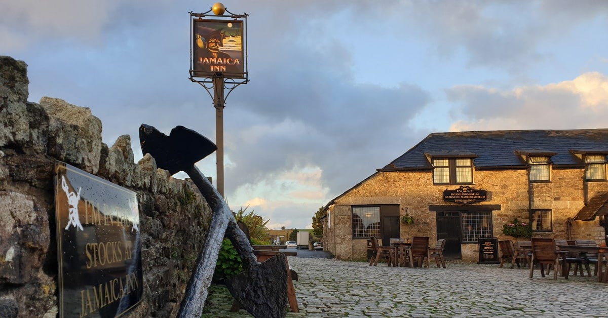 A photo of the Jamaica Inn pub during the 'golden hour', featuring the pub's famous sign.