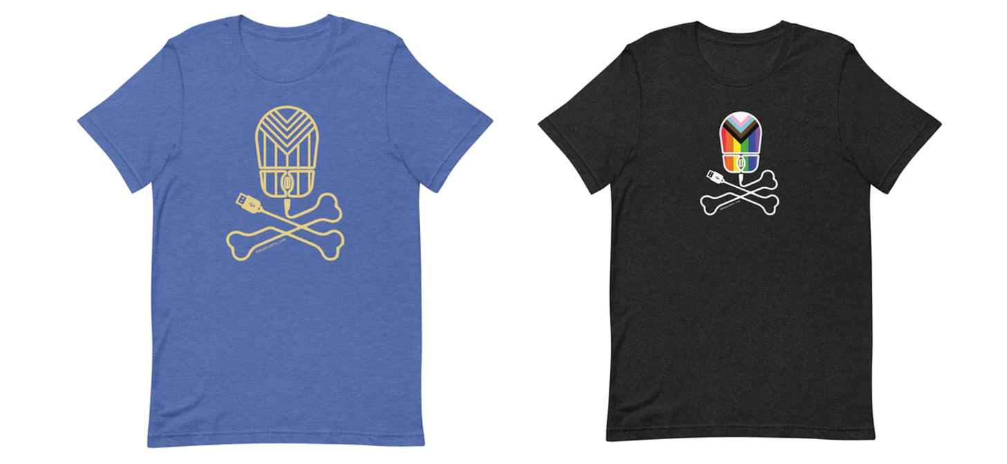 A blue t-shirt with a yellow line drawing of a DDoSecrets logo next to a black t-shirt with a rainbow flag DDoSecrets logo.