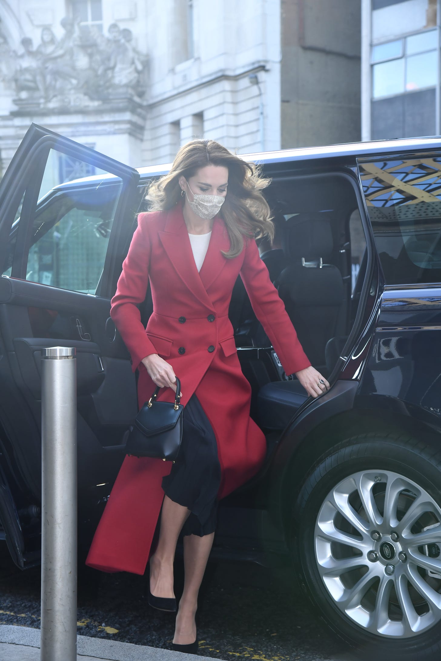 Princess of Wales wearing a mask and red coat getting out of a car