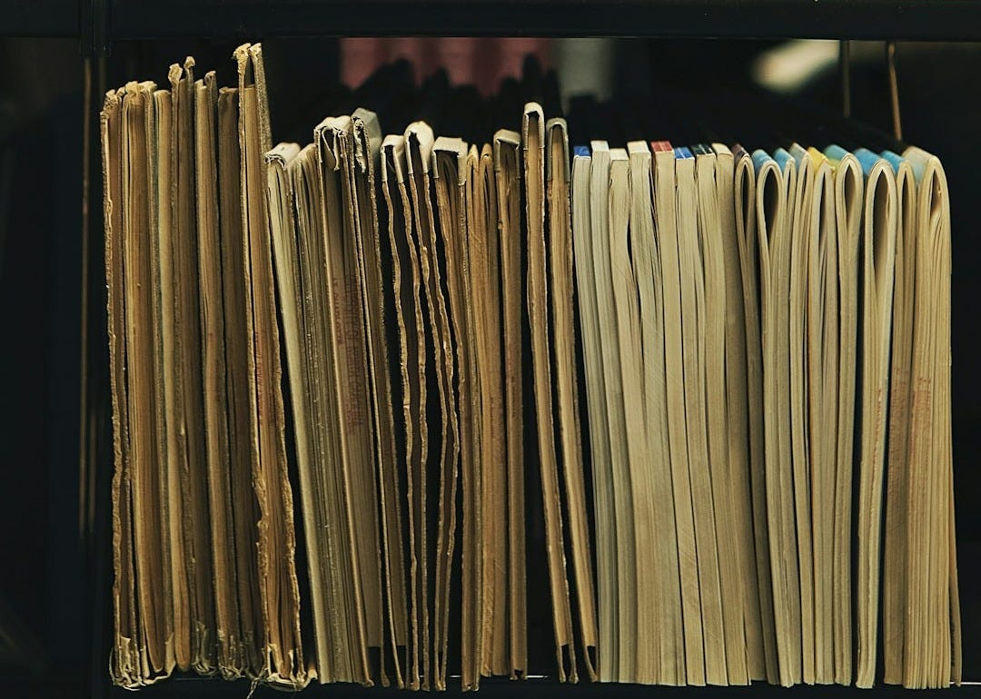 a bookshelf filled with lots of books and papers