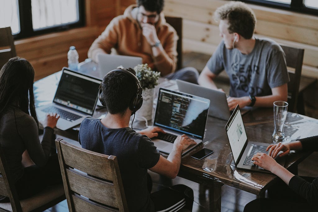 People working at a desk like a startup team.