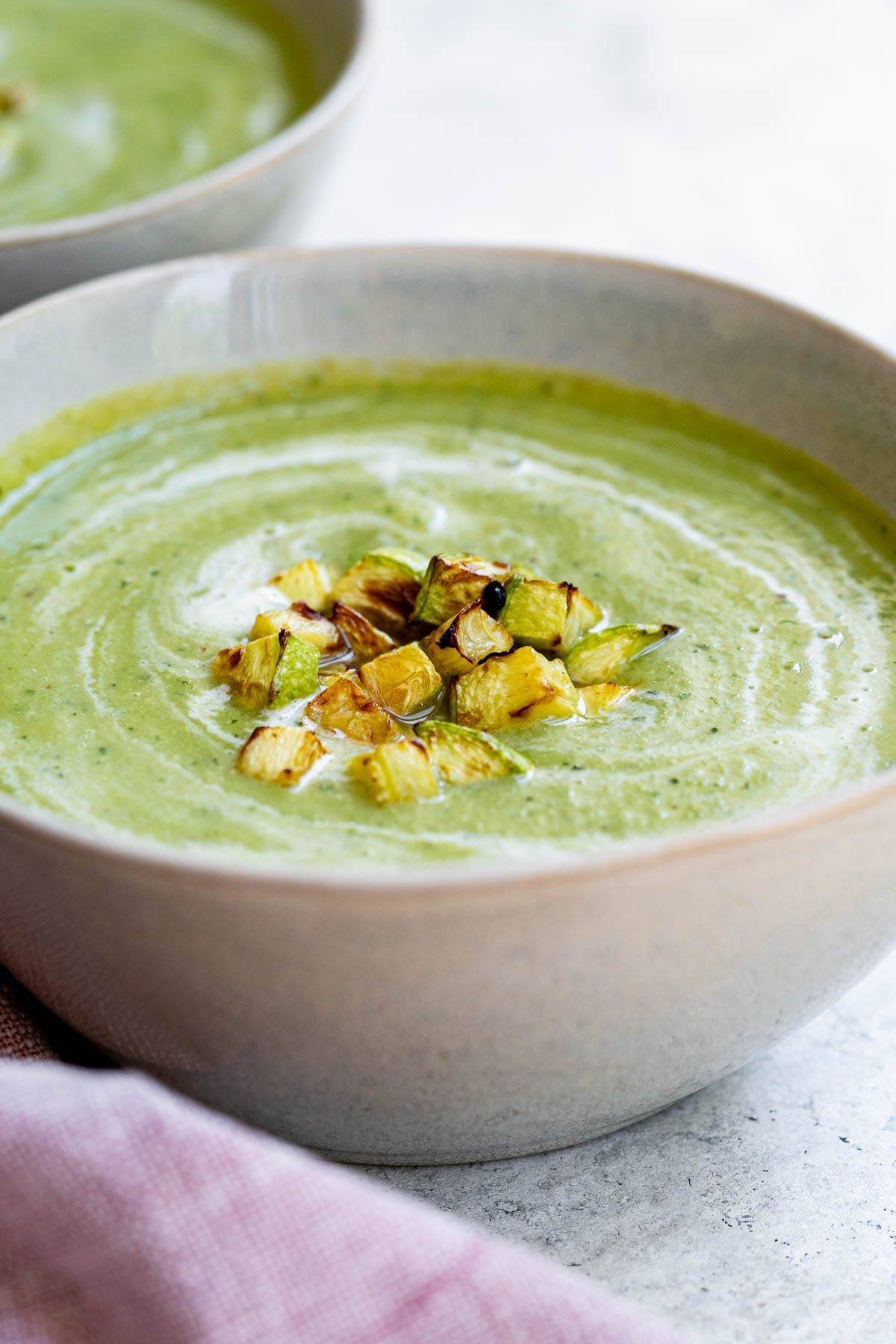zucchini and pea soup garnished with diced zucchinis and cream