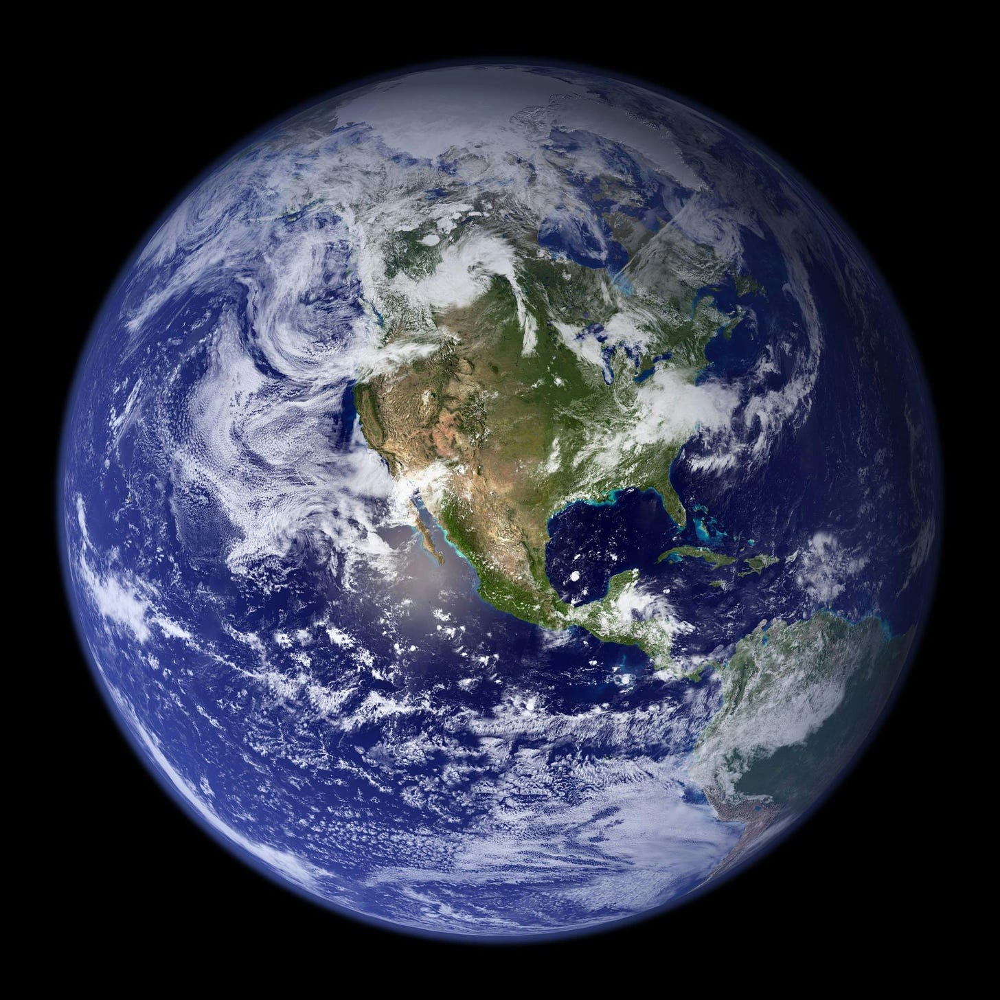 A photo of the Earth as seen from space, showing the continent of North America in the foreground on the blue planet, surrounded by swirling white clouds. 