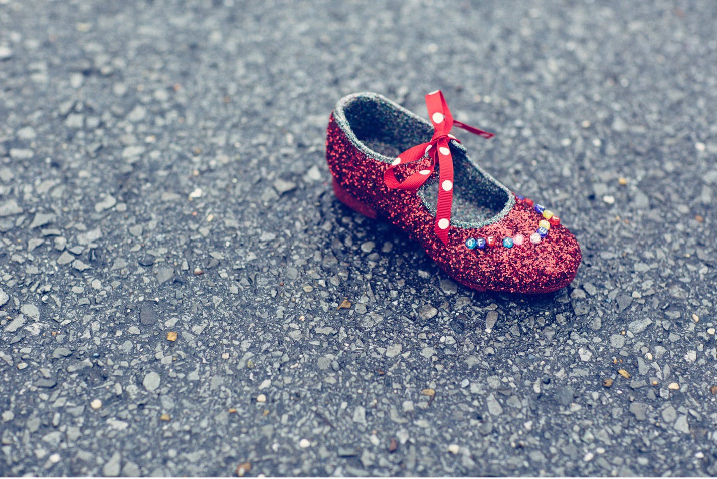 A red glittered children's shoe ready to be thrown in the Muses Mardi Gras parade