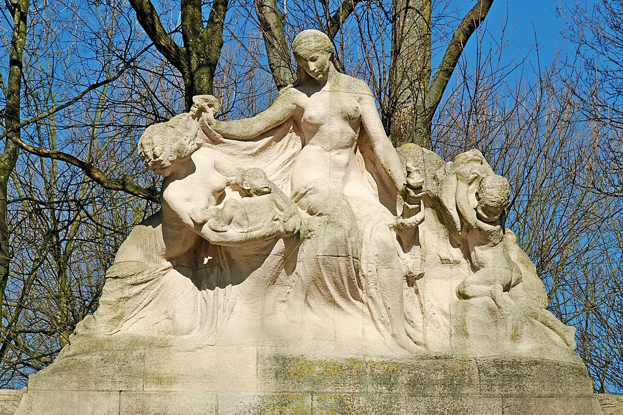 Photo of a monument showing a woman 'welcoming' an African woman and her babies