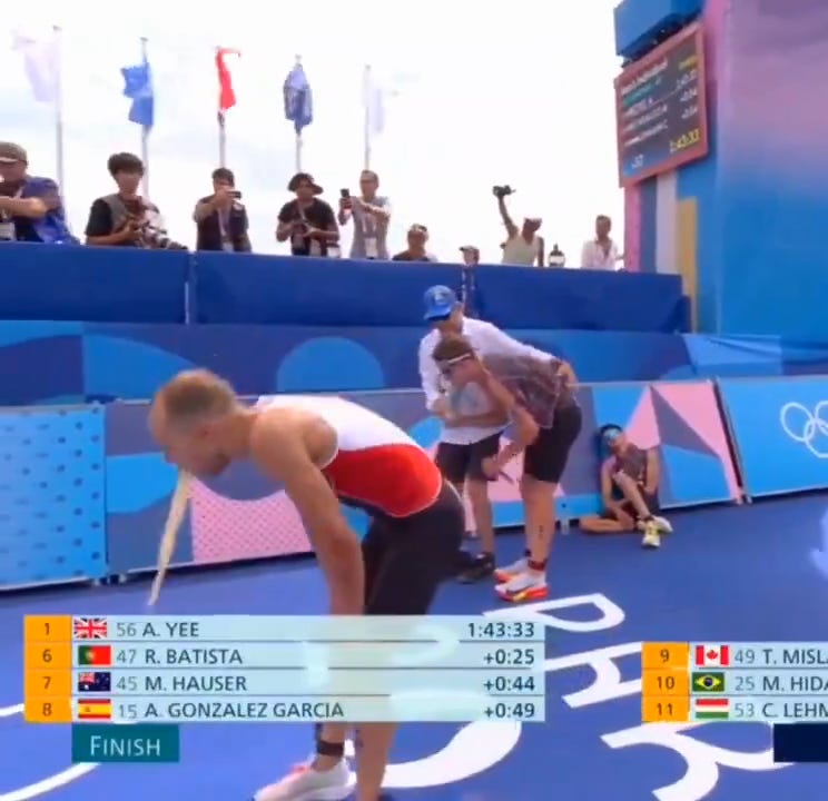 Canada's Tyler Mislawchuk throws up after crossing the finish line following the Men's Triathlon at the 2024 Paris Olympics on July 31, 2024.