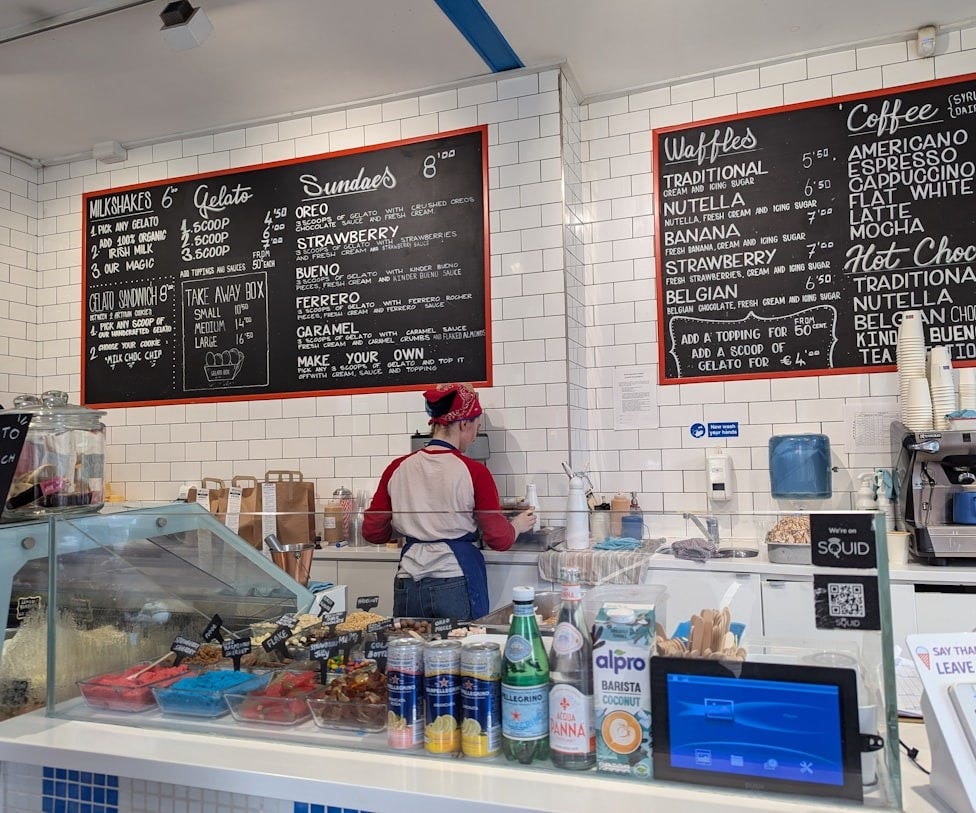 A man standing behind a counter in a restaurant A man standing behind a counter in a restaurant