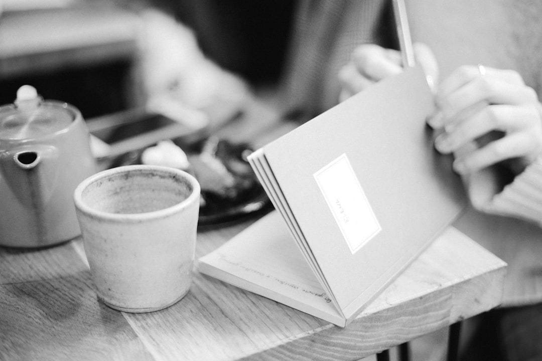 person opening book near coffee cip person opening book near coffee cip