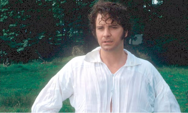 Colin Firth in a white shirt standing in front of trees.