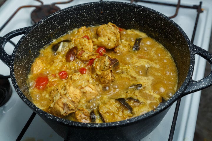Braised eggplant with meat and rice in Israeli spices in a cast-iron high frying pan on the stove.