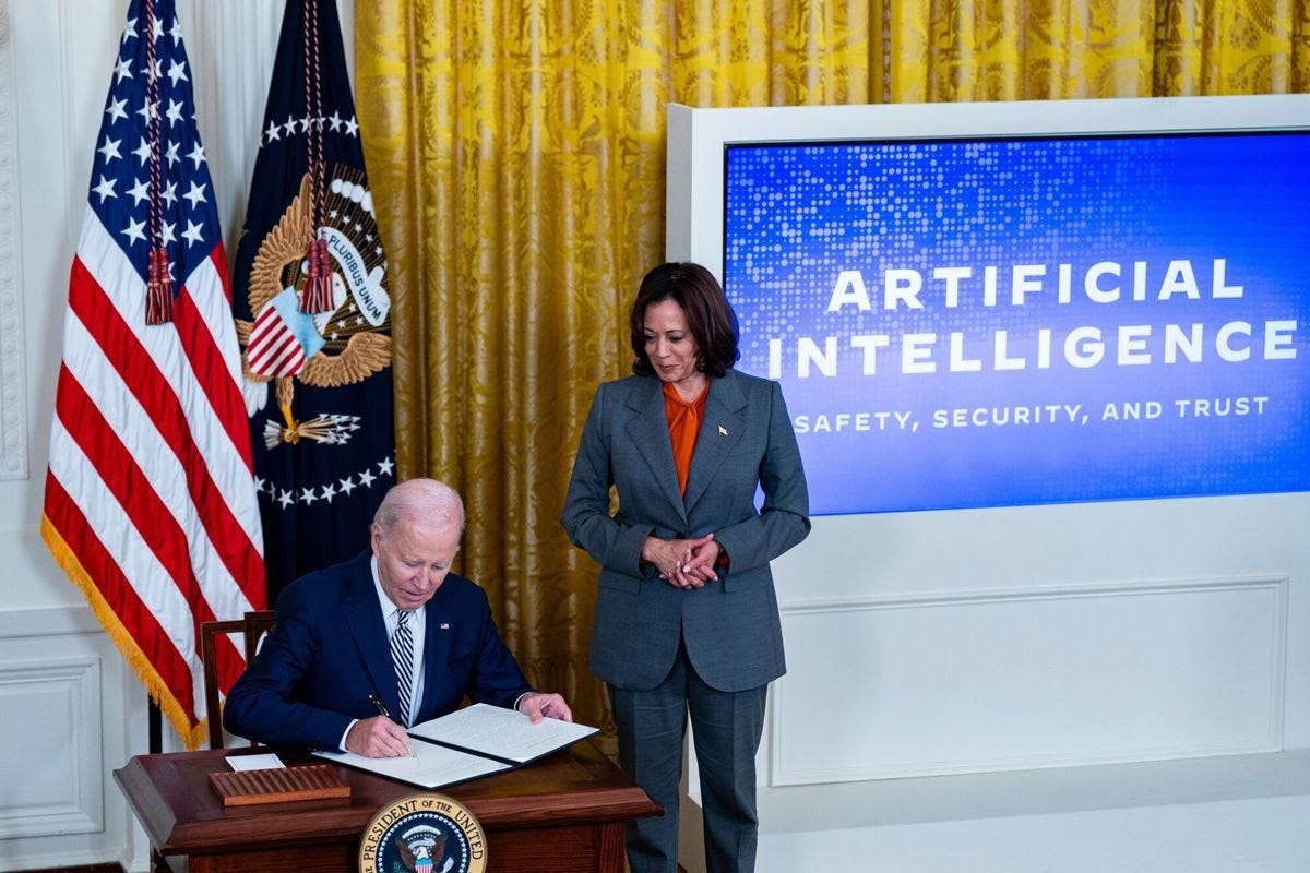 President Biden signs an executive order on artificial intelligence alongside Vice President Harris at the White House on Monday. (Al Drago/Bloomberg News)