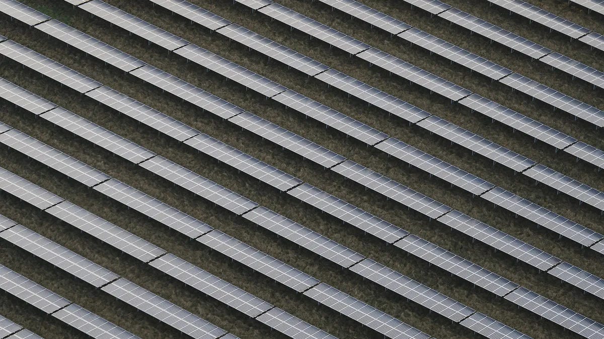 Rows of solar panels are seen from the air.