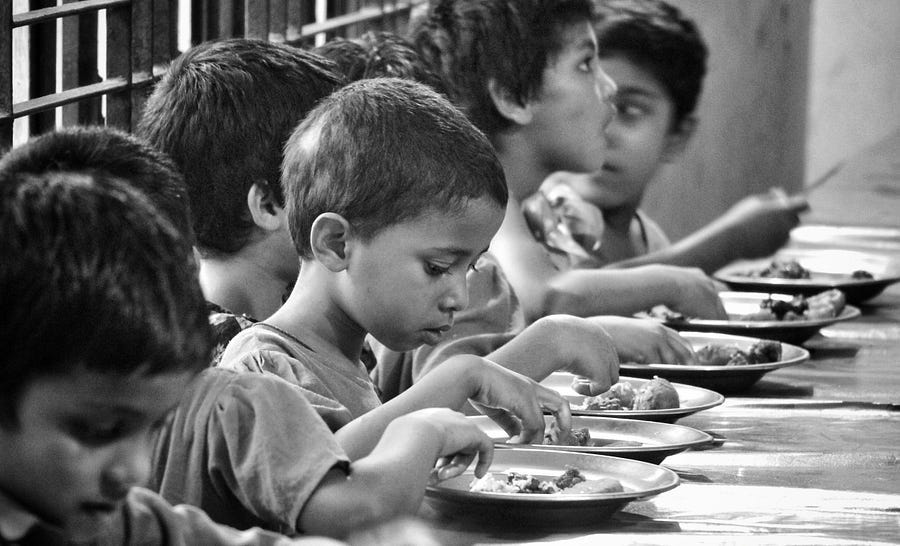 orphan children eating a meal.