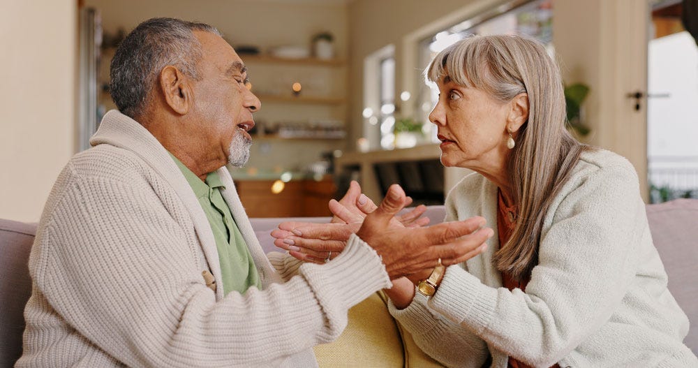 Two people sitting on a couch arguing with each other.