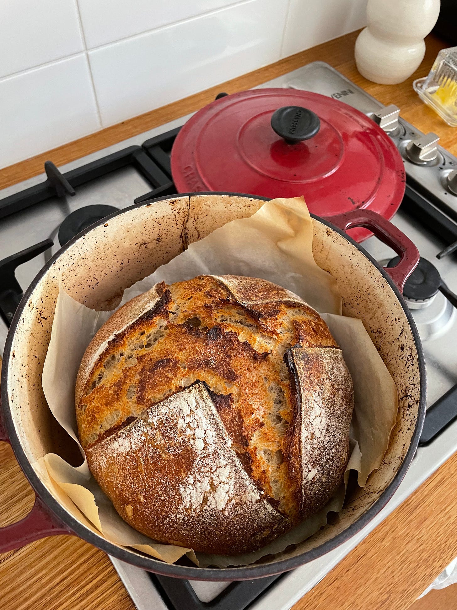 A sourdough loaf just baked instead a red dutch oven.