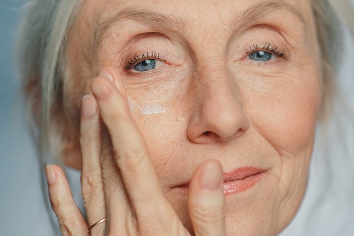 senior woman applying antiaging cream