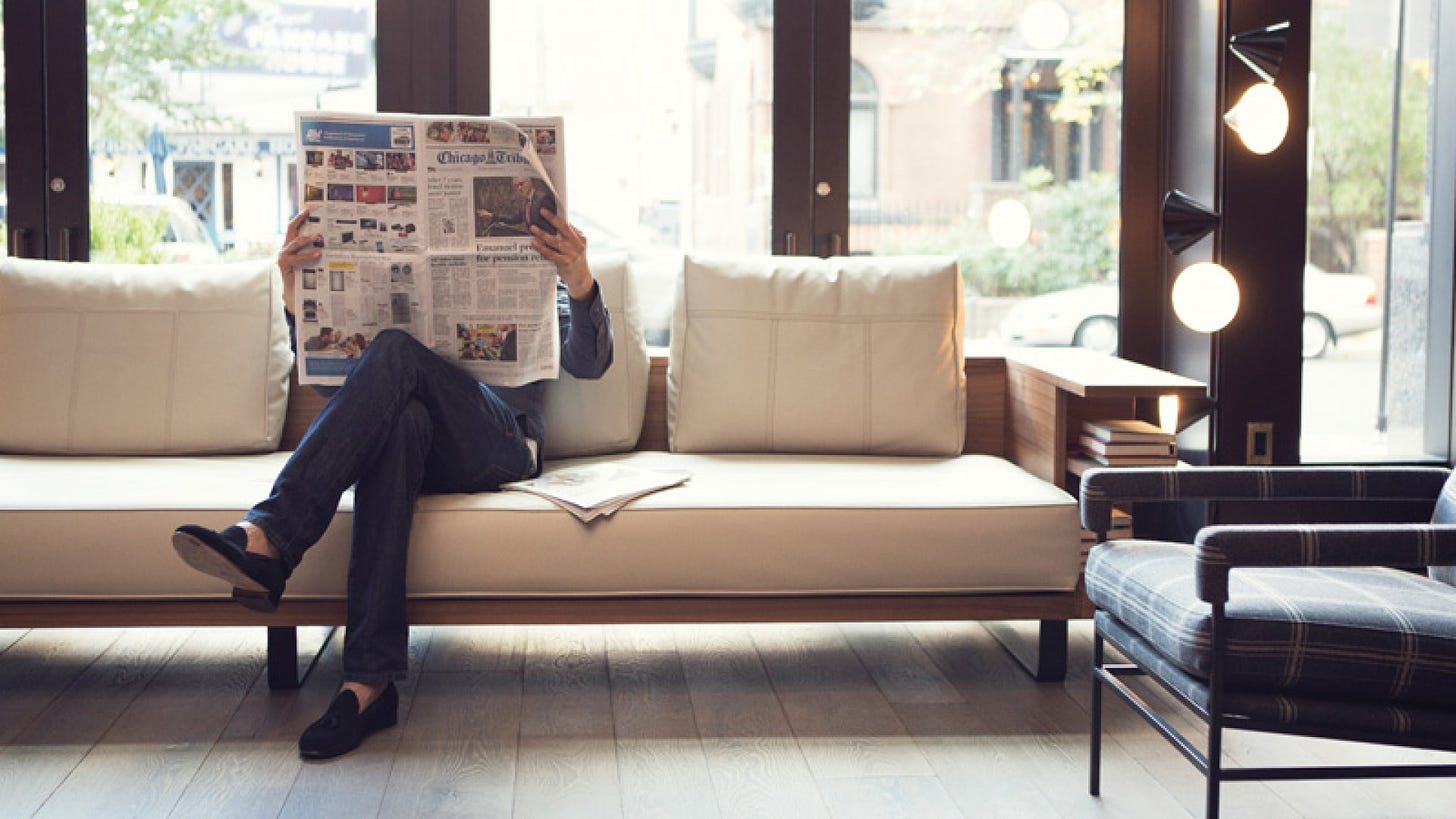 reading newspaper on couch