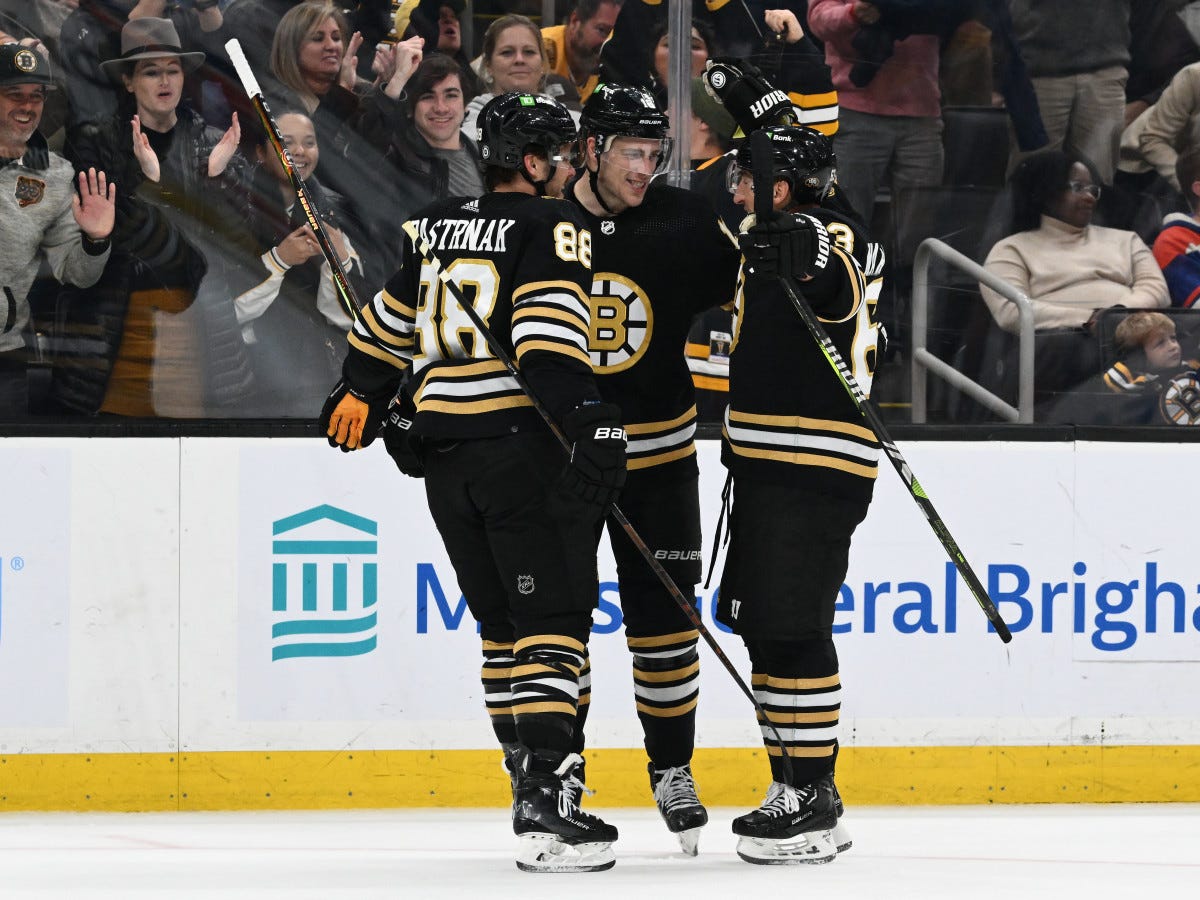 Nov 9, 2023; Boston, Massachusetts, USA; Boston Bruins center Charlie Coyle (13) celebrates with right wing David Pastrnak (88) and left wing Brad Marchand (63) after scoring a goal against the New York Islanders during the third period at the TD Garden. Mandatory Credit: Brian Fluharty-USA TODAY Sports