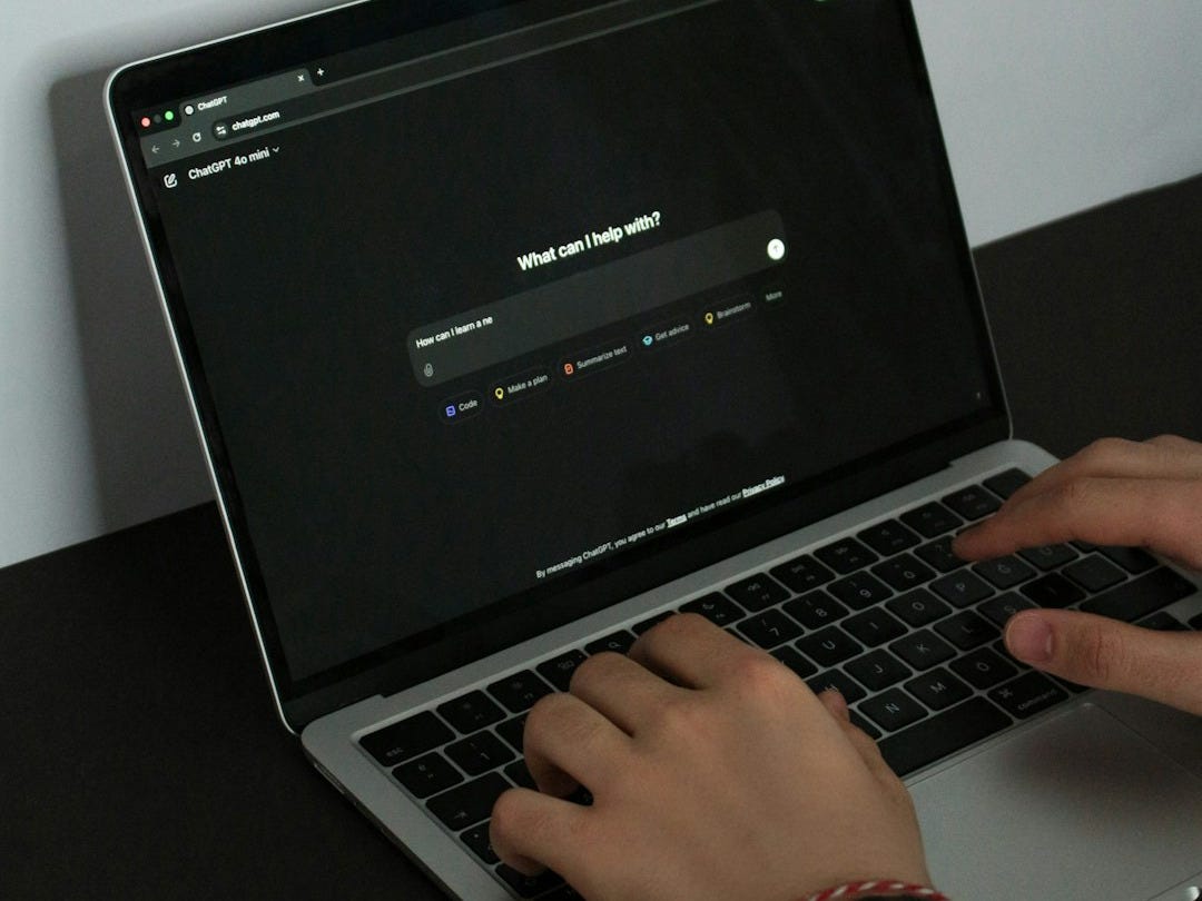 A person typing on a laptop on a table A person typing on a laptop on a table
