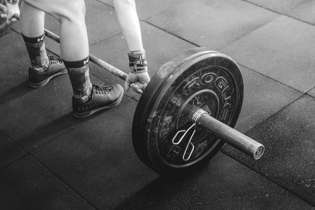 person holding barbell person holding barbell